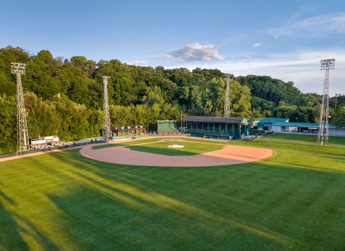 Jordan, MN - Empty Small Town Baseball Stadium Diamond Surrounded By Tall Trees In The Evening Golden Light